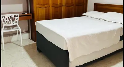 a bedroom with a bed with a chair and a desk at Apartamento Alvarez in Cartagena de Indias
