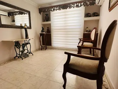 a living room with a chair and a mirror at Apartamento Alvarez in Cartagena de Indias