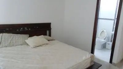 a bedroom with a bed and a toilet in a room at Cabaña Villa Flower Gold in Juan de Acosta