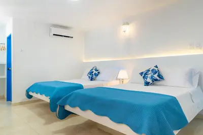 two beds in a room with blue and white at Casa Caribe Colonial in Barranquilla