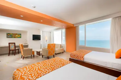 a hotel room with two beds and a window at Hotel Dann Cartagena in Cartagena de Indias