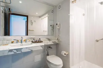 a bathroom with a toilet and a sink and a mirror at Hotel Dann Cartagena in Cartagena de Indias