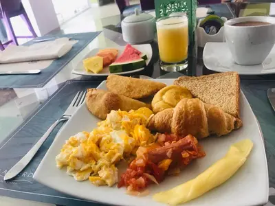 a plate of breakfast food on a table at Hotel Isla Verde in Tubará