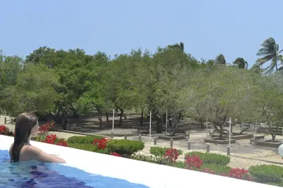 a woman in a swimming pool looking at a park at Hotel Isla Verde in Tubará