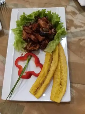 a plate of food with lettuce and meat and peppers at Hotel Isla Verde in Tubará