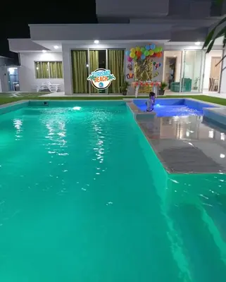 a boy sitting in a swimming pool at night at Sun Beach in Puerto Colombia