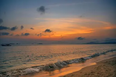 a sunset over a beach with the ocean at Sun Beach in Puerto Colombia
