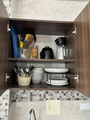 a kitchen cabinet with plates and utensils in it at Deusades Apartamentos in Cartagena de Indias