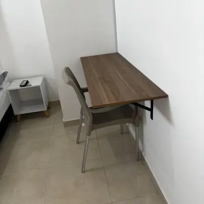 a wooden table and a chair in a room at Deusades Apartamentos in Cartagena de Indias