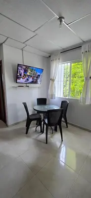a dining room with a table and chairs and a tv at Deusades Apartamentos in Cartagena de Indias