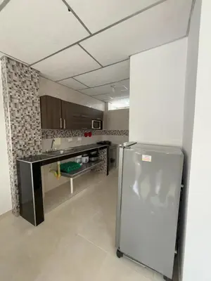 a kitchen with a refrigerator in the middle of a room at Deusades Apartamentos in Cartagena de Indias
