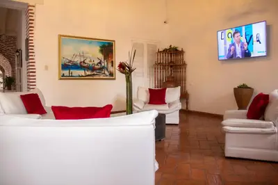 a living room with white furniture and a vase with flowers at Casa Villa Colonial By Akel Hotels in Cartagena de Indias