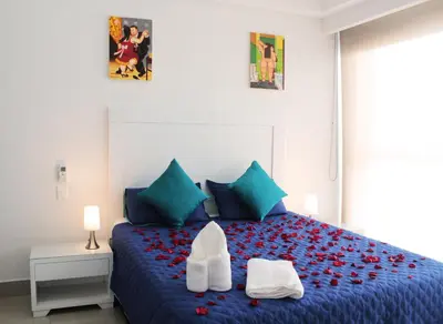 a bedroom with a blue bed with a pair of shoes on it at Apartamentos Cartagena Oceano - Eliptic in Cartagena de Indias