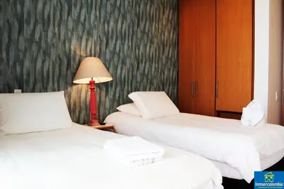 two beds in a room with a lamp and a lamp at Apartamento Encantador - H2 Condominio in Cartagena de Indias