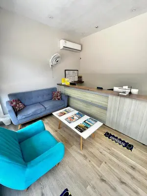 a living room with a blue couch and a table at Hostal Lumar in Barranquilla
