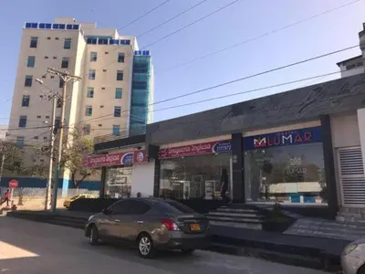 a car is parked in front of a store at Hostal Lumar in Barranquilla