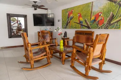a room with three chairs and a table and a tv at Hotel Veleros Cartagena in Cartagena de Indias