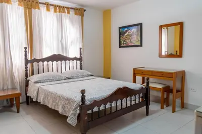 a bedroom with a bed and a table and a mirror at Hotel Veleros Cartagena in Cartagena de Indias