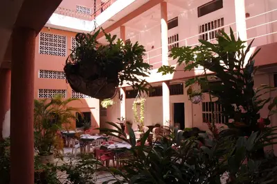 a courtyard with tables and potted plants in a building at Hotel Montecarlo Beach in Tolú