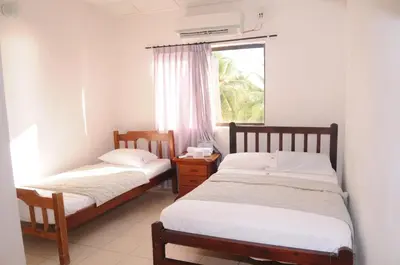 two beds in a room with a window at Hotel Montecarlo Beach in Tolú