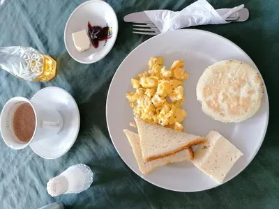 a plate of food with eggs and toast and a cup of coffee at Hotel Montecarlo Beach in Tolú