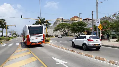 a bus and a car on a city street at Comfort La Española in Cartagena de Indias