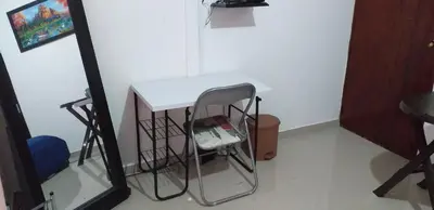 a small white table with a chair next to a mirror at Comfort La Española in Cartagena de Indias