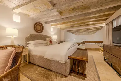 a bedroom with a large bed and a television at Casa Pestagua Relais Châteaux in Cartagena de Indias