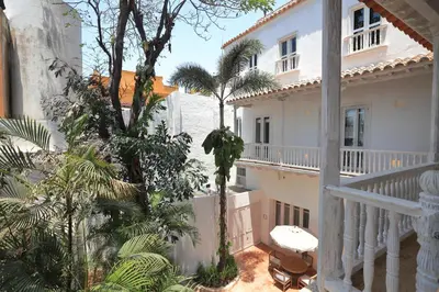 a balcony of a white house with palm trees at Casa Pestagua Relais Châteaux in Cartagena de Indias