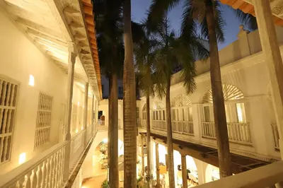a hallway with palm trees in a building at Casa Pestagua Relais Châteaux in Cartagena de Indias