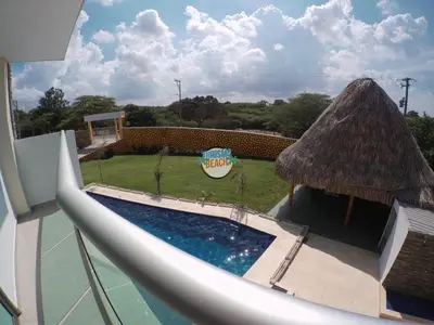 a pool with a slide and a grass roof at Special Life Beach in Tubará