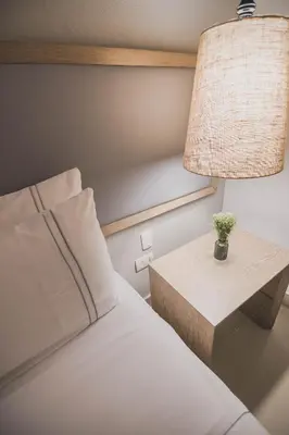 a bedroom with a bed and a table with a lamp at Hotel Santa Cecilia B&B in Cartagena de Indias