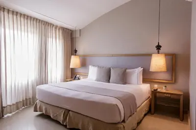 a bedroom with a large white bed with two lamps at Hotel Santa Cecilia B&B in Cartagena de Indias