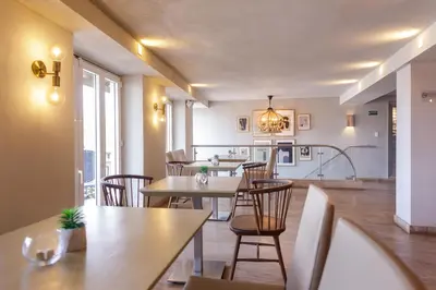 a restaurant with tables and chairs and a kitchen at Hotel Santa Cecilia B&B in Cartagena de Indias