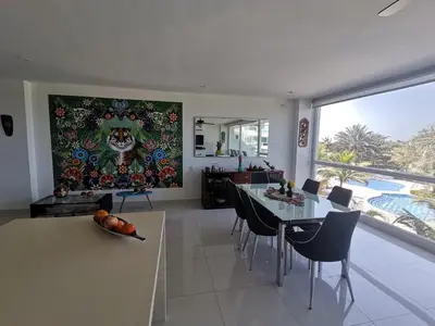 a kitchen and dining room with a painting on the wall at Karibana Espectacular in Cartagena de Indias