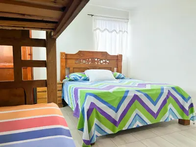 a bedroom with a bed with a colorful comforter at La Terraza de Estella in Cartagena de Indias