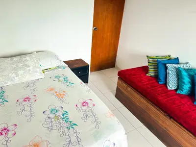 a bedroom with a bed and a red couch at La Terraza de Estella in Cartagena de Indias