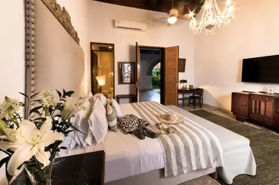 a bedroom with a bed and a television and a table at Hotel Boutique Casa Del Arzobispado in Cartagena de Indias