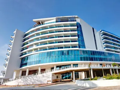 a large building with glass windows on the side of it at Las Americas Torre Del Mar in Cartagena de Indias