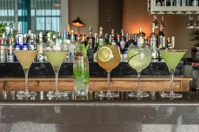 a row of different cocktails sitting on a bar at Las Americas Torre Del Mar in Cartagena de Indias