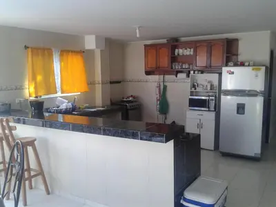 a kitchen with a white refrigerator and a counter top at Casa de Campo Palmarito in Tubará