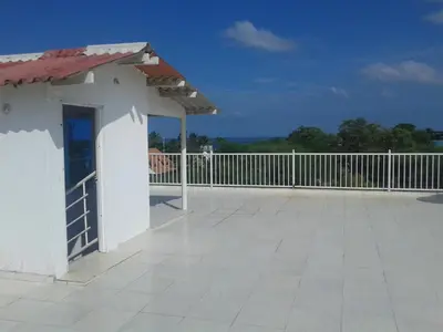 a small white building on a roof with a fence at Casa de Campo Palmarito in Tubará