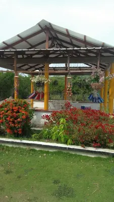 a pavilion with flowers and plants in a park at Casa de Campo Palmarito in Tubará