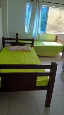 a bedroom with a green bed and a window at Casa de Campo Palmarito in Tubará