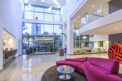 a living room with a purple couch in a building at NH Collection Royal Smartsuites in Barranquilla