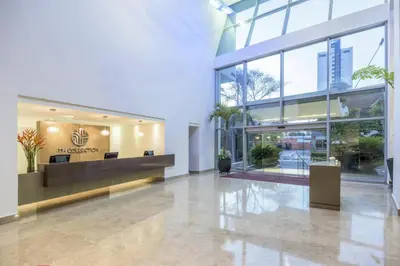 a lobby of a building with windows and plants at NH Collection Royal Smartsuites in Barranquilla