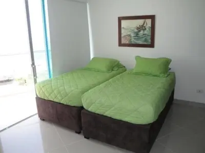 two twin beds in a bedroom with a picture on the wall at Apartamento Cartagena Edif Seaway 935 - Apto 501 Fotos Instagram apartamentocartagena501 in Cartagena de Indias