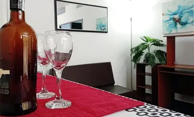 two wine glasses sitting on a table next to a bottle at Apartamento Aeromar, Santa Marta in Santa Marta