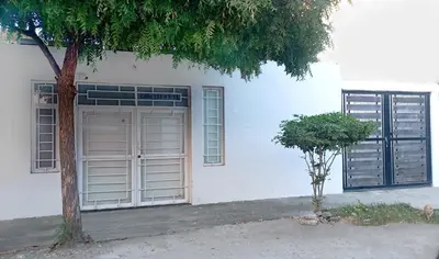 a white building with two windows and a tree at Apartamento Aeromar, Santa Marta in Santa Marta