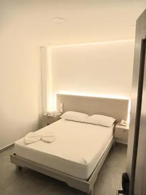 a bedroom with a white bed with two white pillows at Hotel San Sebastian Real in Cartagena de Indias
